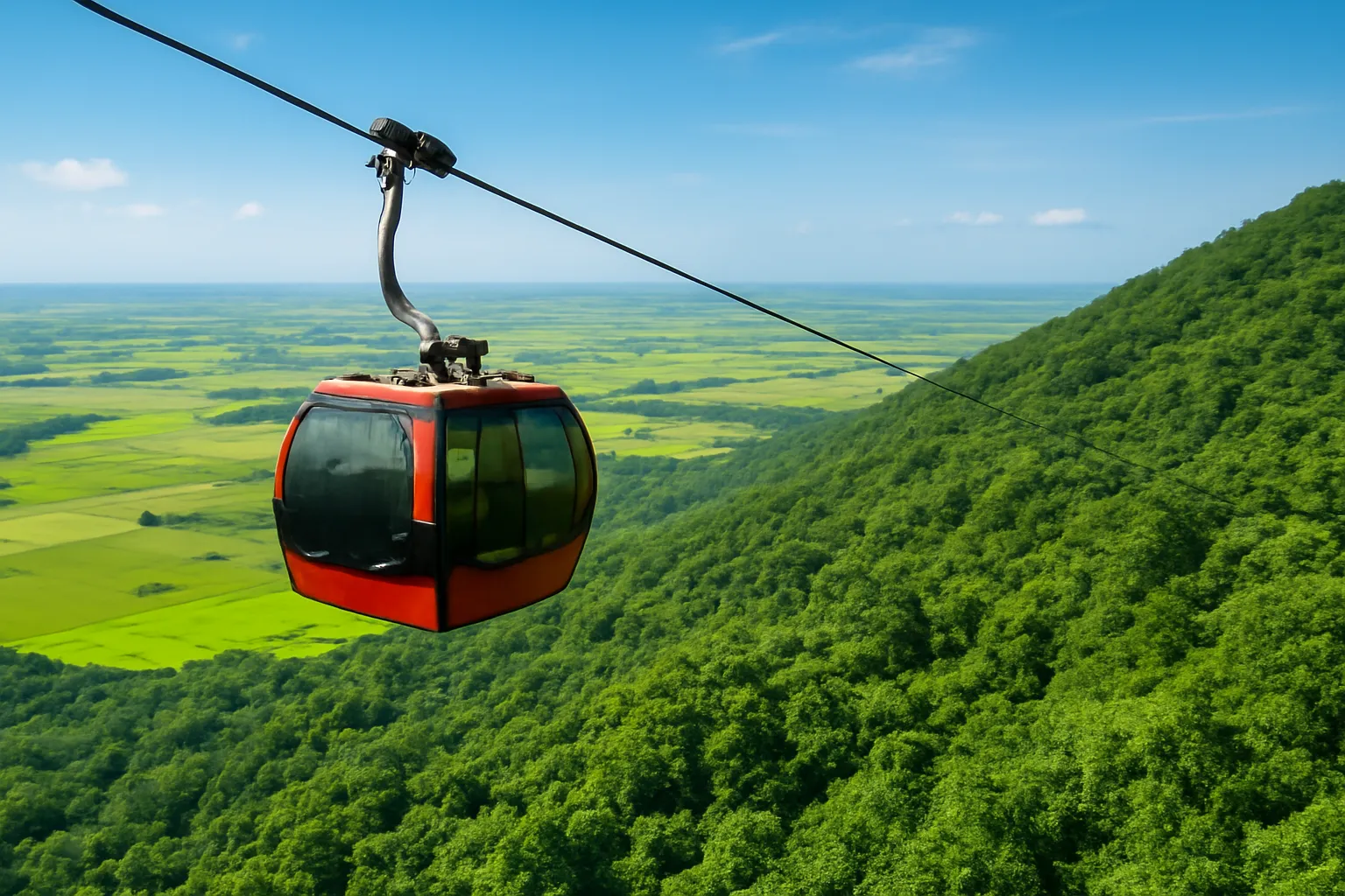 Cabin cáp treo màu đỏ lướt trên sườn rừng xanh, đồng bằng trải phía dưới